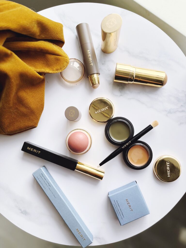 Flat lay of Merit Beauty products on a white marble table